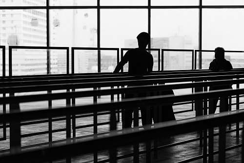 person silhouette of two person inside glass building people