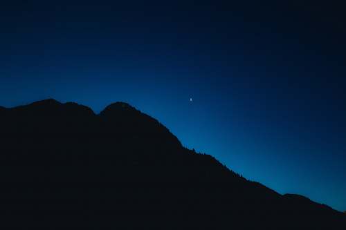night silhouette of mountain under blue sky mountain