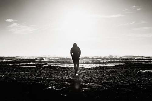 person man standing near ocean grayscale photography people