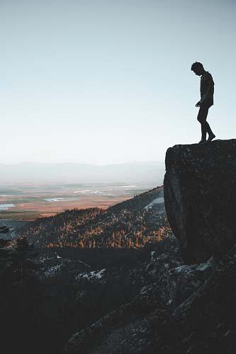 person man standing on cliff people