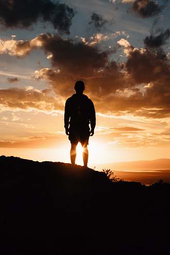 person man standing on mountain during sunset people