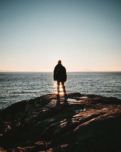 person man standing on seacliff standing