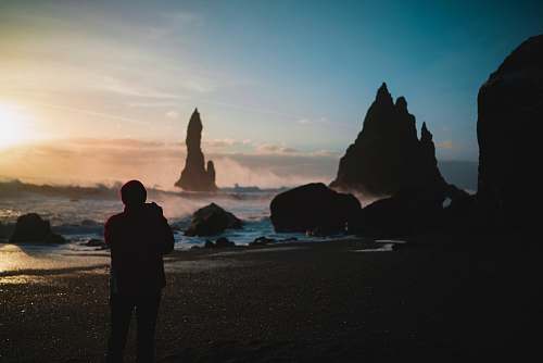 nature person standing in the beach during golden hour outdoors