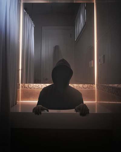 person person wearing hoodie inside room silhouette