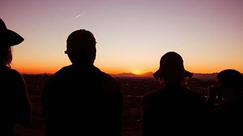 person silhouette of four standing people during golden hour people