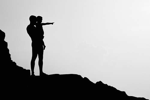 person silhouette of man carrying child black-and-white