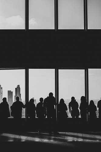 person silhouette of people looking at windows black-and-white