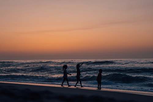 person silhouette of person on seashore during daytime silhouette