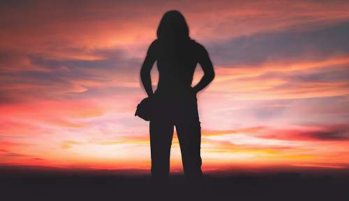 person silhouette of person standing during golden hour standing