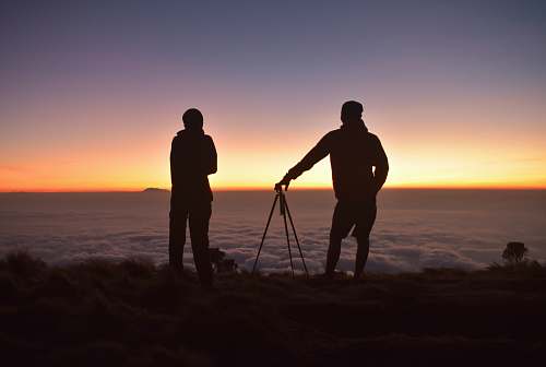 people silhouette of two people tripod