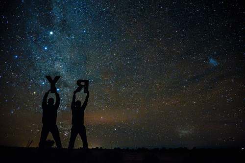 person silhouette of two person holding letters R and Y under starry sky people