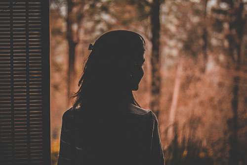person silhouette of woman near window silhouette