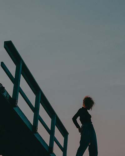 banister silhouette of woman standing beside rail handrail