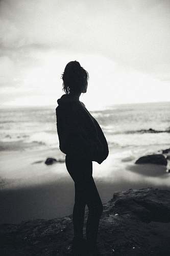 person silhouette of woman standing near sea standing