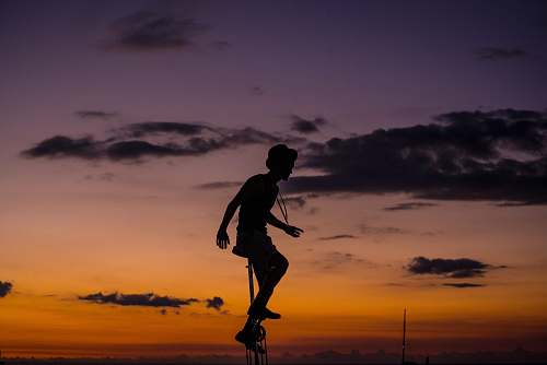 person silhouette photo of man riding unicycle people