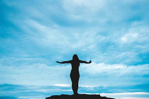 nature silhouette photography of woman raising her hands outdoors
