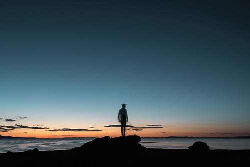 person sillhouette of a man facing the beach standing