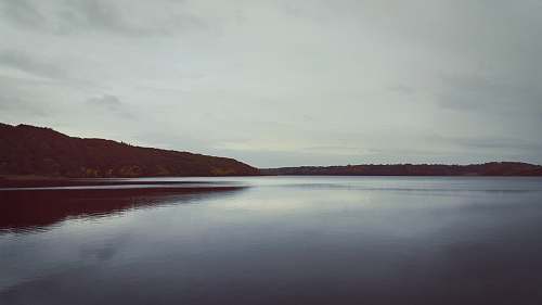grey body of water near mountain during daytime water