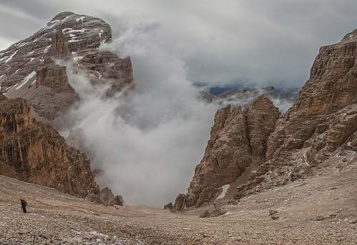 slope landscape photography of foggy mountain rocks descent