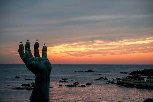 outdoors hand statue in seashore silhouette
