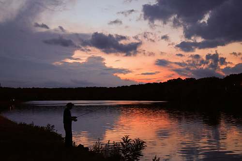 outdoors landscape photo of a fisherman at sunset human