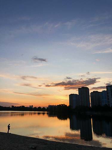 outdoors man standing near body of water sky