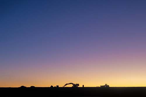 outdoors silhouette of excavator against yellow light sky