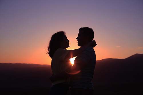 people silhouette of hugging couple sky