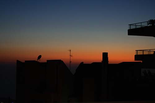 silhouette silhouette of mountains and building during golden hour bird