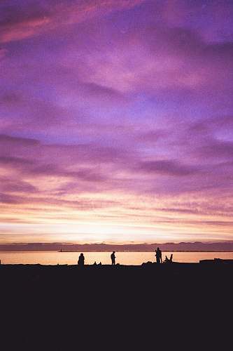 outdoors silhouette of person standing near body of water sunset
