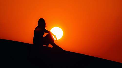 outdoors silhouette of woman sitting on ground sun