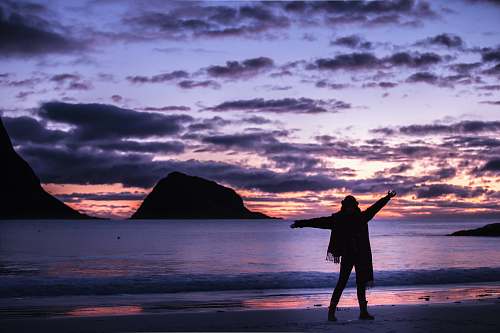 outdoors silhouette photography of woman standing on shore sea