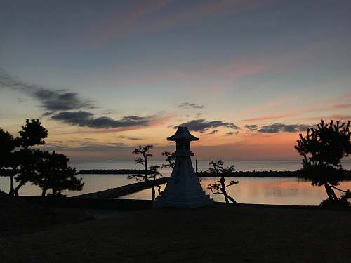 silhouette view of fish ponds during golden hour sunset