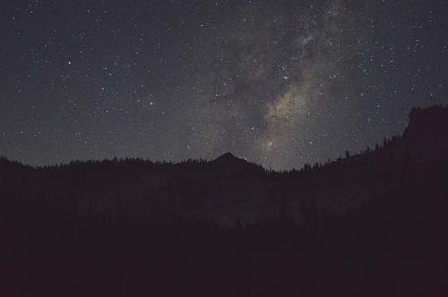 space silhouette of a mountain during night galaxy