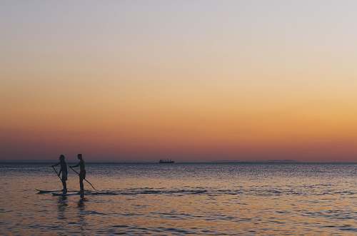 sea two person kayaked on ocean during golden hour water