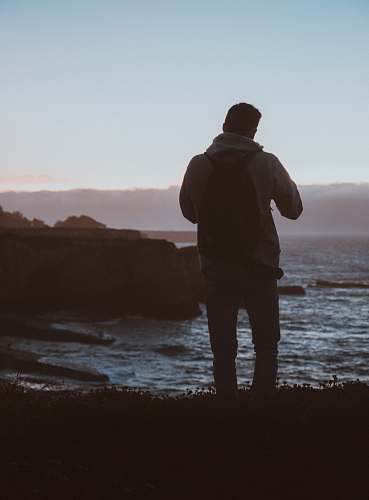 nature man standing beside body of water ocean