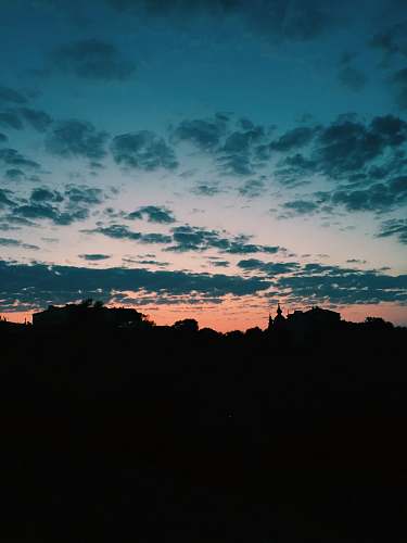 nature silhouette of building under cloudy sky dawn
