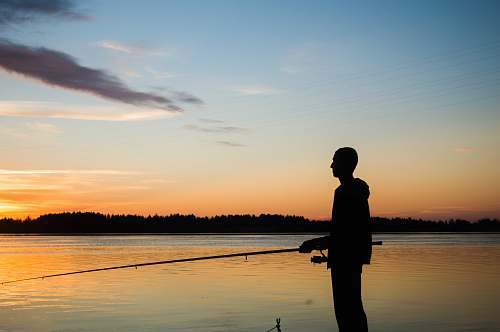 human silhouette of person fishing water