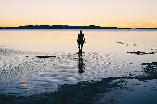 silhouette silhouette of person standing on body of water great salt lake