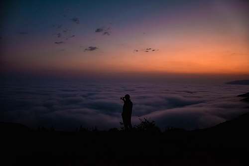 nature silhouette of standing person during golden hour sky