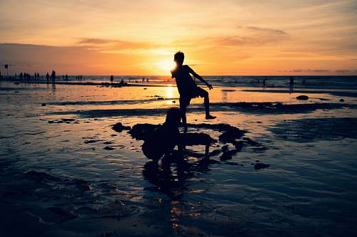nature silhouette photography of toddler standing outdoors ocean