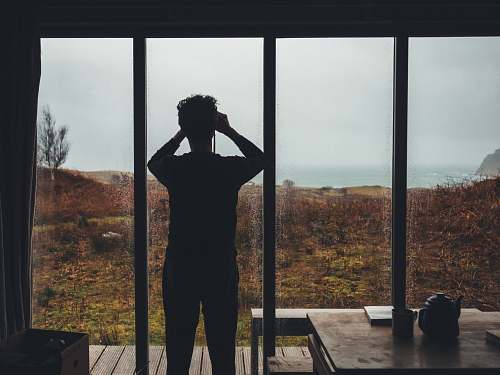 human man standing near glass window person