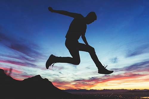 silhouette silhouette of man jumping near mountain cape town