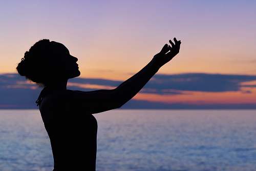 yoga silhouette of woman raising her right hand water