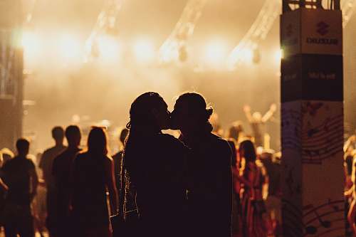 people man and woman kissing in the middle of concert human