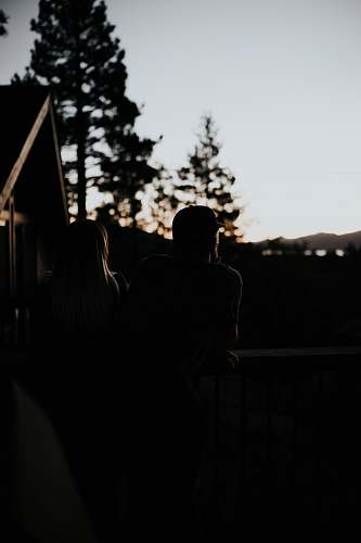 silhouette man and woman sitting beside handrail human