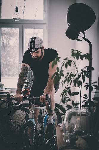 bicycle man riding on gray rigid bicycle near window bike