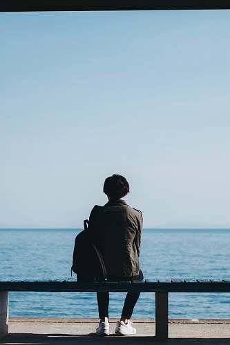 human man sitting on bench blue