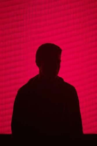 human man standing against red wall silhouette