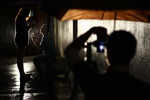 silhouette man taking a photo of couple propose